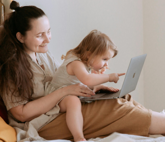 Mama versucht zu arbeiten während das Kind mit ihr spielen will.