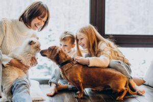 Kinder und Mama kuscheln mit Katze und Hund