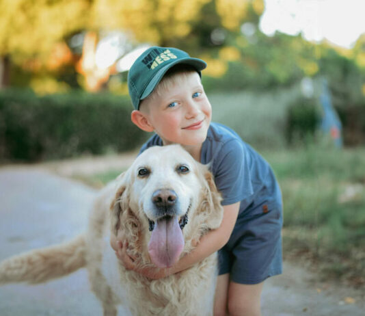 Kind kuschelt mit Hund