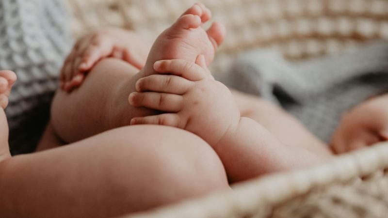 Baby greift mit der Hand den Fuß