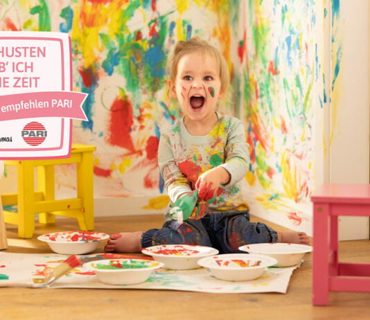 Kindheitsmomente genießen: Kleines Mädchen bemalt Wände mit bunter Farbe.