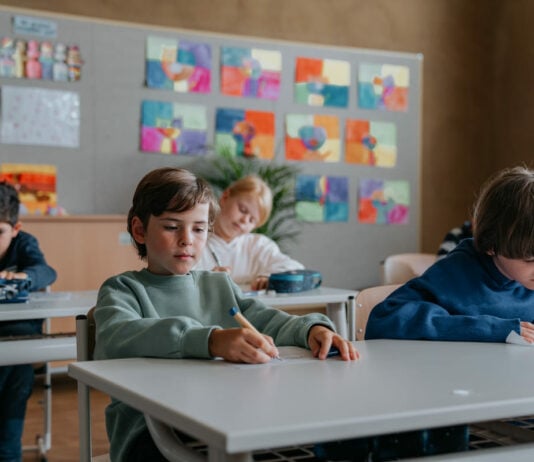 Kinder sitzen in der Schule vor Schulaufgabe