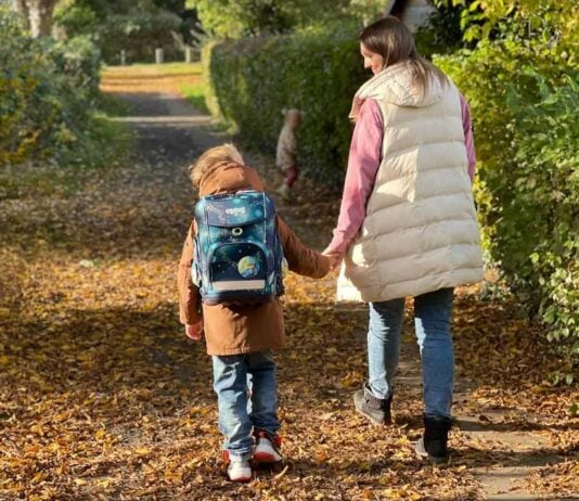 Mama geht mit Sohn und Tochter zur Schule